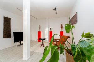 a living room with a tv and a plant at Artist Loft Experience Stylish 4-Bedroom Stay in Montreuil