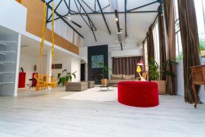 a living room with a red ottoman in the middle at Artist Loft Experience Stylish 4-Bedroom Stay in Montreuil