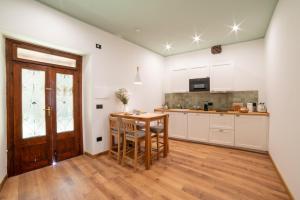 a kitchen with white cabinets and a wooden table at Palazzo Bottino in Bolsena