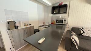 a living room with a couch and a table with a remote control at L’appartement du Micocoulier in Salon-de-Provence
