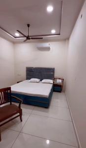 ein Schlafzimmer mit einem Bett und einem Stuhl in der Unterkunft V2 Guest House in Jalandhar