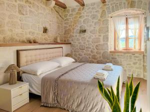 a bedroom with a bed and a window and a plant at NEW! Holiday Home Retro Stone House in Živogošće