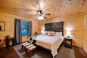 a bedroom with a bed and a wooden ceiling at Close to All, Mini Golf, Hot Tub, Fire-Pit, Swing Set in Broken Bow