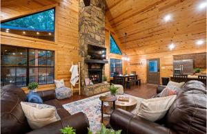 a living room with a couch and a stone fireplace at Close to All, Mini Golf, Hot Tub, Fire-Pit, Swing Set in Broken Bow