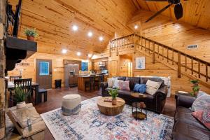 a living room with a couch and a staircase at Close to All, Mini Golf, Hot Tub, Fire-Pit, Swing Set in Broken Bow