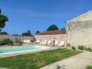 a swimming pool in a yard next to a building at Villa Marie in Courçon
