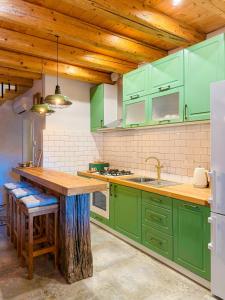 a kitchen with green cabinets and a wooden counter top at NEW! Holiday Home Retro Stone House in Živogošće