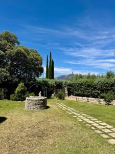 a garden with a stone path in the grass at Quinta El Escorial in Escorial
