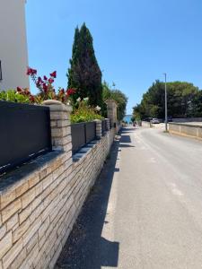 Una pared de ladrillos con plantas al costado de una carretera. en Villa Jalan, en Vrsi