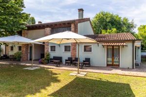 a house with two umbrellas in the yard at Agriturismo San Bartolomeo in Monselice