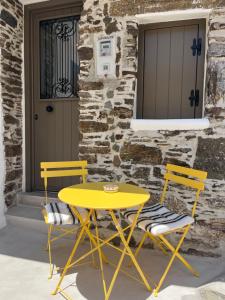 two yellow chairs and a yellow table and chairs at Estrella house in Kithnos