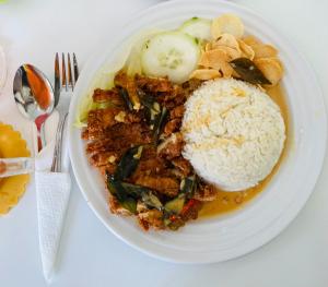 a white plate of food with rice and vegetables at Mamucha Grand Lodge in Arusha