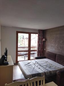 a room with a bed and a couch and a window at valmeinier 1800 appartement in Valmeinier