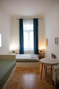 a bedroom with a bed and a window with blue curtains at Hostel Moravia Ostrava in Ostrava