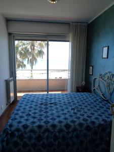 um quarto com uma cama e vista para o oceano em appartamento sul mare Massasso em Ventimiglia