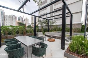 a patio with a table and chairs at Otima localizacao metro Sacoma Aeroporto Congonhas Av Paulista Great location 80m subway near Av Paulista and Congonhas Airport Smart TV 50 free channels 600gb WiFi Pool Gym in Sao Paulo