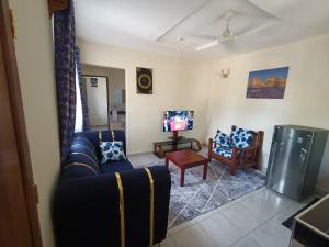 a living room with a couch and a tv at Empire BnB in Ukunda