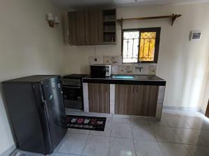 a small kitchen with a sink and a refrigerator at Empire BnB in Ukunda