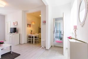 ein weißes Wohnzimmer mit einem Tisch und einem Spiegel in der Unterkunft Center Apartment Tina in Pula