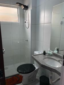 a bathroom with a toilet and a sink and a shower at Apartamento próximo a Prainha in Aquiraz
