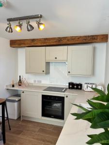 a kitchen with white cabinets and a stove top oven at The Cottage at Clive in Clive