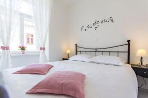 ein Schlafzimmer mit einem großen weißen Bett mit rosa Kissen in der Unterkunft Center Apartment Tina in Pula