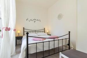 Schlafzimmer mit einem Bett mit weißer Bettwäsche und rosa Kissen in der Unterkunft Center Apartment Tina in Pula