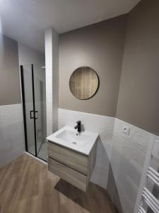 Appartement rez-de-chaussée في كارينتان: حمام مع حوض أبيض ومرآة +3 صور