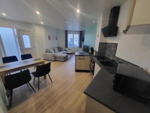 Appartement rez-de-chaussée في كارينتان: غرفة معيشة كبيرة مع مطبخ وغرفة معيشة