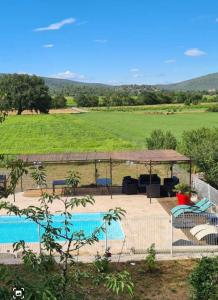 a pool with a gazebo and a view of a field at En famille et entre amis in Néoules