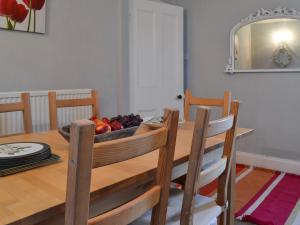 a dining room table with a bowl of fruit on it at Gaerwen in Criccieth +15 photos