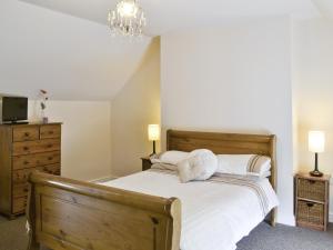 a bedroom with a bed with white sheets and pillows at John Wesley Cottage in West Kyo