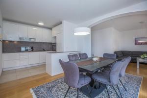a kitchen and dining room with a table and chairs at Casa Moderna - New Spacious Apartments in Lokva Rogoznica