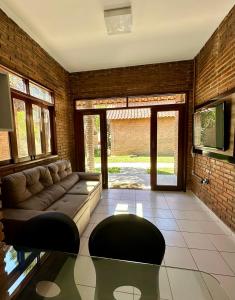 a living room with a couch and a brick wall at Casa Praia do Frances in Marechal Deodoro