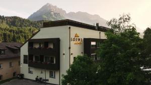 ein Hotel mit einem Schild an der Seite eines Gebäudes in der Unterkunft Loewe Dolomites in Innichen
