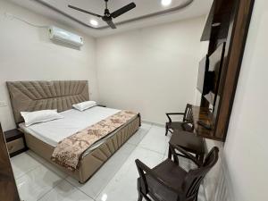 a bedroom with a bed and a tv and a chair at V2 Guest House in Jalandhar