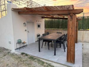 ein Holztisch und Stühle auf einer Terrasse in der Unterkunft Maison 5 in Pellaro