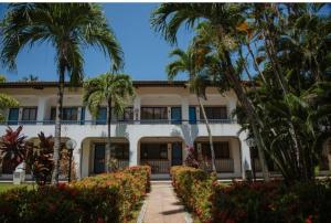 een uitzicht op een gebouw met palmbomen bij Guarajuba Summer Flat in Guarajuba