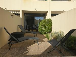 a patio with chairs and a table in a building at Waterfront studio with terrace in Lacanau