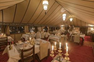 an overhead view of a restaurant with white tables and candles at Nour Luxury Camp in Merzouga