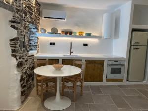a kitchen with a white table and a sink at Estrella house in Kithnos