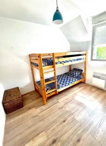 two bunk beds in a room with wooden floors at L echappée d Opale - Jardin Privé et à 5 min de Ste Cécile Plage in Camiers