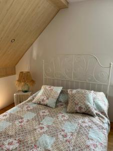 a bedroom with a bed with a bedspread and pillows at Wiatrakówka in Kosewo