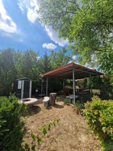a picnic shelter with a bench and a picnic table at Margó Nyaraló in Balatonederics