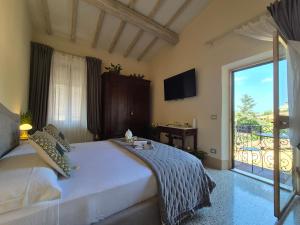 a bedroom with a large bed and a balcony at Residenza d'Epoca CAVALIERE - Romantic Rooms in Bibbona