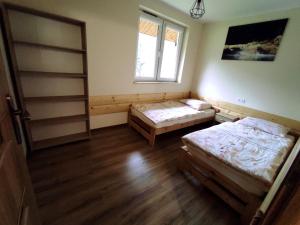a room with two beds and a window at Domki nad rzeką Solinką in Terka