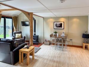 a living room with a couch and a table at Toad Hall Cottage in Earls Colne