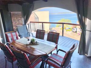 曼德雷Apartment Grey的阳台上的桌子和椅子，可欣赏海景