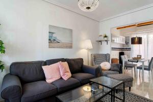 a living room with a couch and a table at Encantadora casa vacacional en El Chaparral in Torrevieja