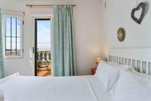 a bedroom with a white bed and a window at Encantadora casa vacacional en El Chaparral in Torrevieja +16 photos